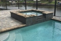 added spa to existing pool, with spill over, paver deck, brick coping, pebble interior