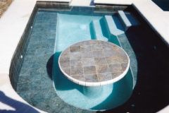 Spa with bench and table added to swimming pool renovation