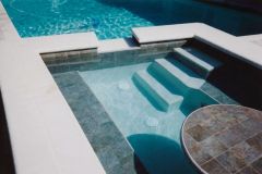 large party spa added to swimming pool, including tile and pebble interior