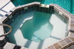 large spa with seating and spillover in addition to pool renovation