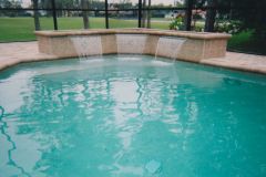 Sheer descent waterfall added with raised wall, coping, deck, tile, pool interior surface